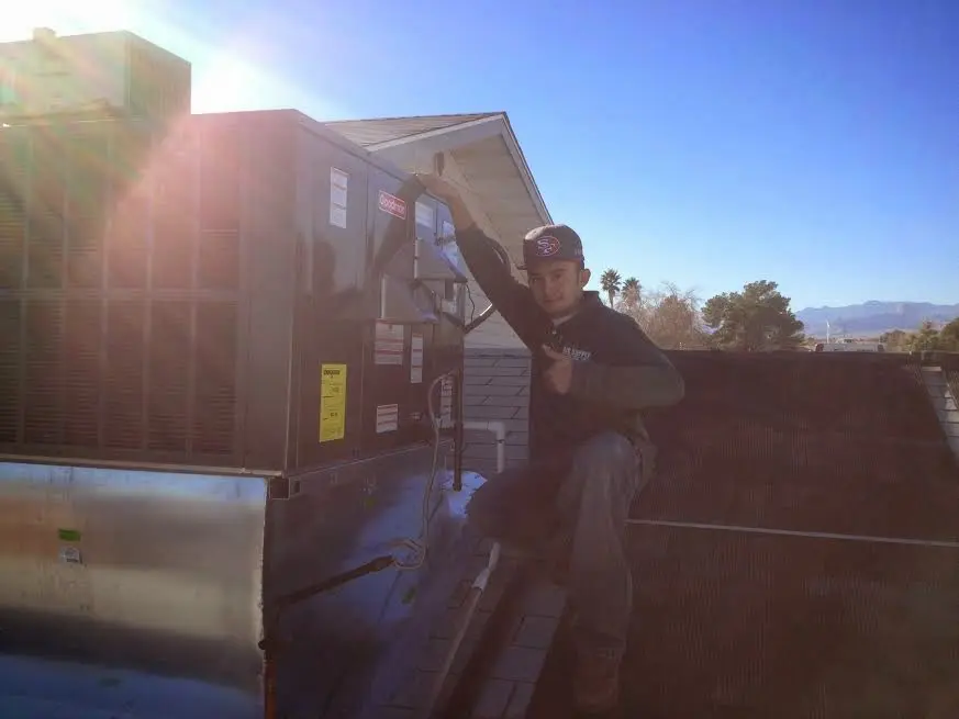 HVAC technician performing AC Tune-Up on a rooftop unit in Temple Hills